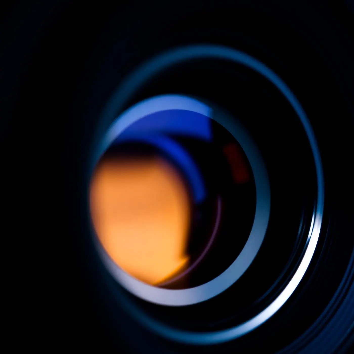 Macro detail of a cinema lens aperture with chrome ring and lime flare
